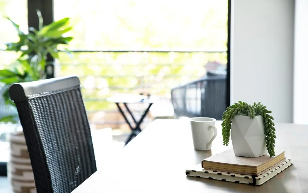 Outdoor seating area with modern chairs and potted plants overlooking garden