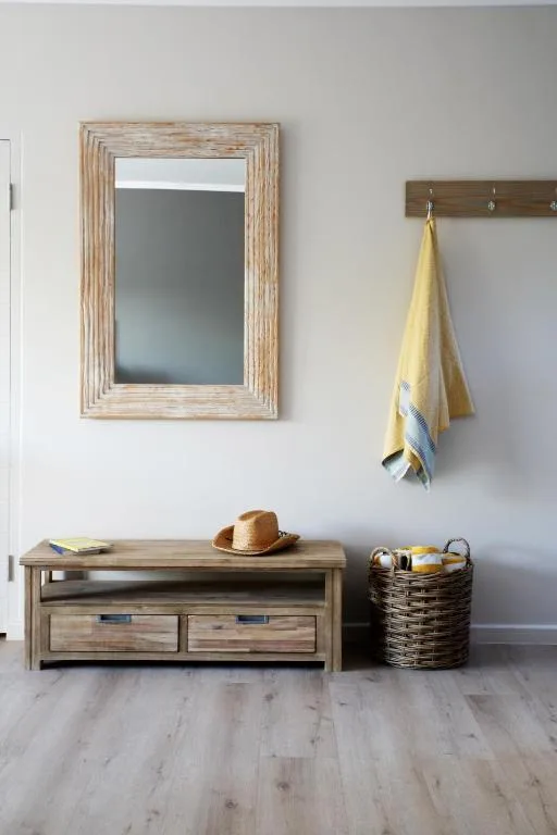Rustic wooden entryway bench with framed mirror and woven storage baskets