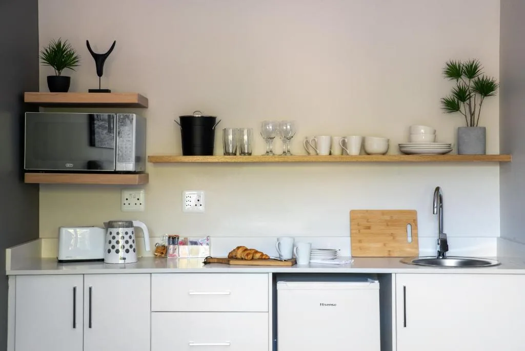 Modern kitchen with open shelving, microwave, and organized dining essentials