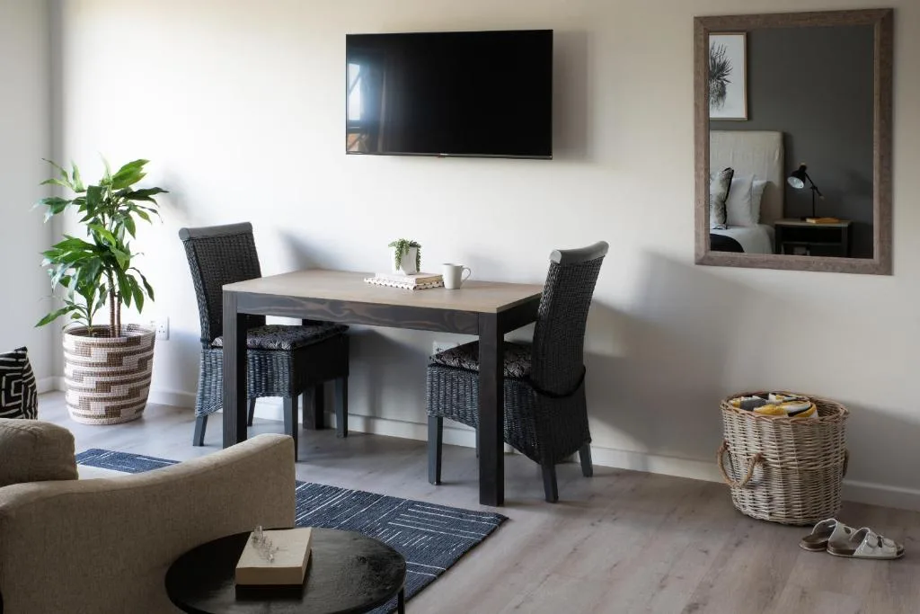 Open-plan lounge and dining area with TV, sofa, and dining table