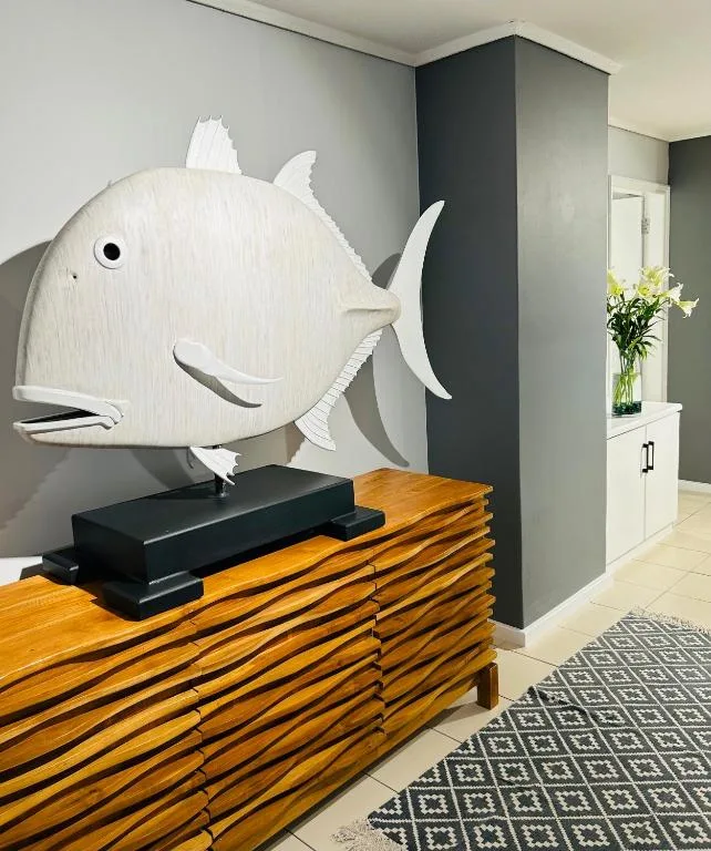 White wooden fish sculpture decorates wooden reception desk with flowers