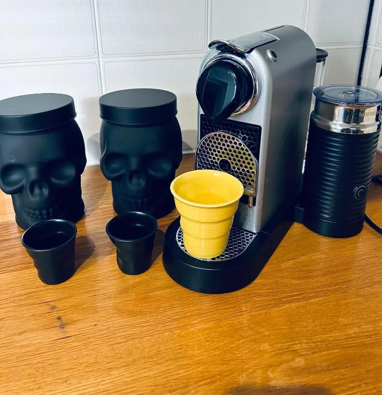 Coffee maker with matching mugs and accessories on wooden countertop