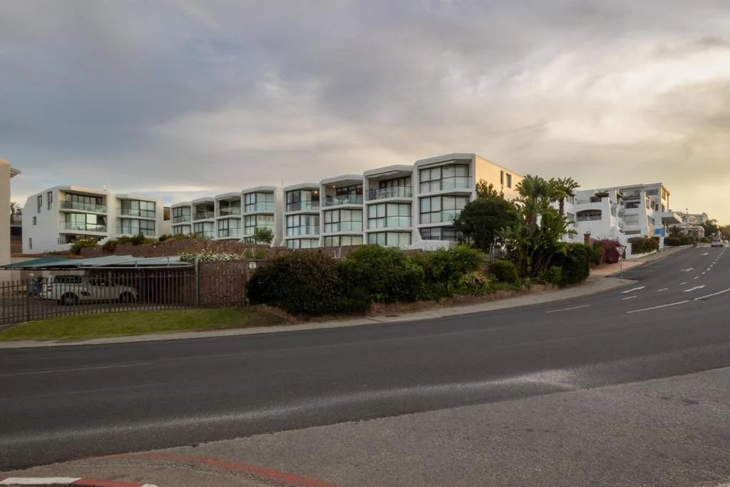 Modern white apartment building with curved architecture and large windows