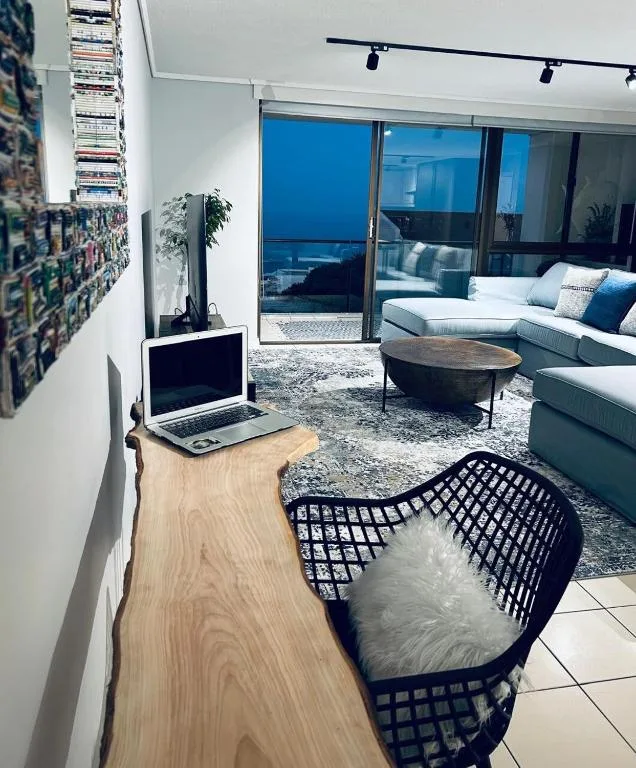 Modern lounge with grey sofa, ocean views through sliding glass doors