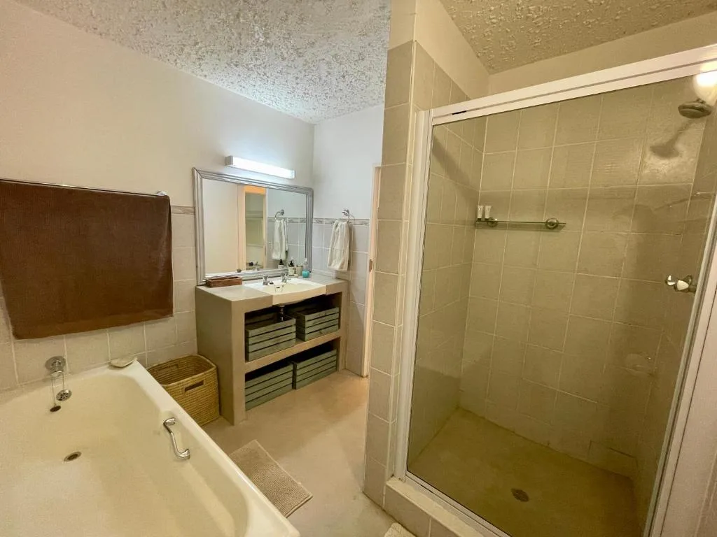 Spacious bathroom with bathtub, vanity sink, and walk-in shower enclosure