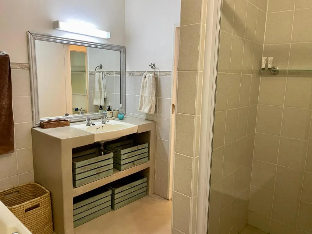 Spacious bathroom with double vanity, mirror, and enclosed shower enclosure
