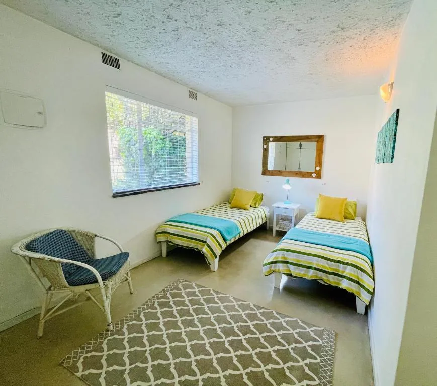 Bright twin bedroom with colorful striped bedding and yellow accent pillows