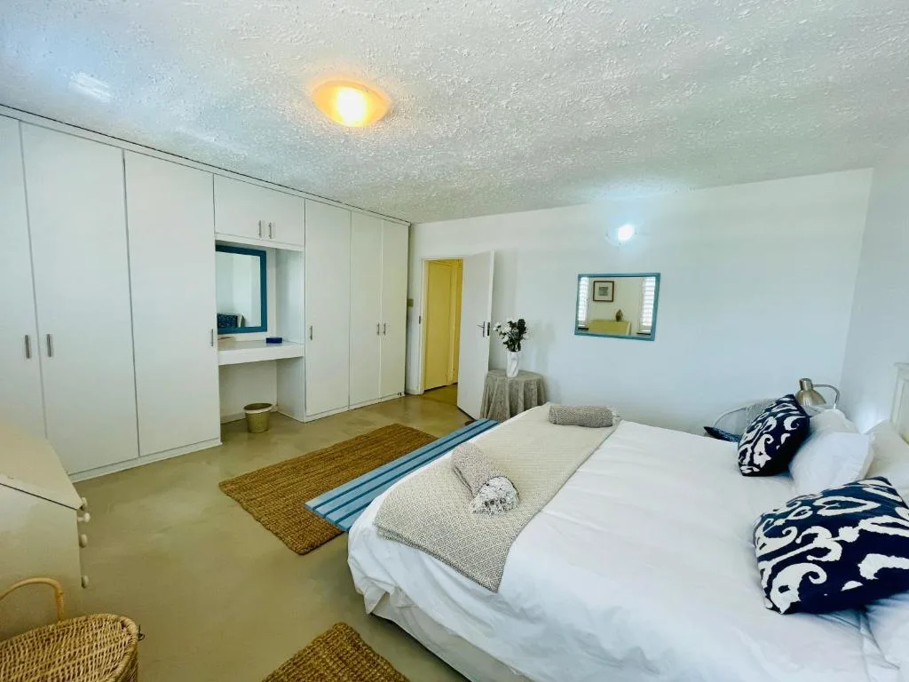 Spacious bedroom with queen bed, built-in wardrobes, and ensuite vanity area