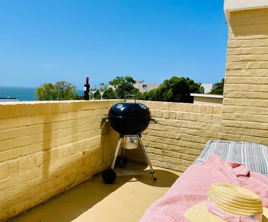 Rooftop deck with braai grill overlooking ocean and coastal vegetation