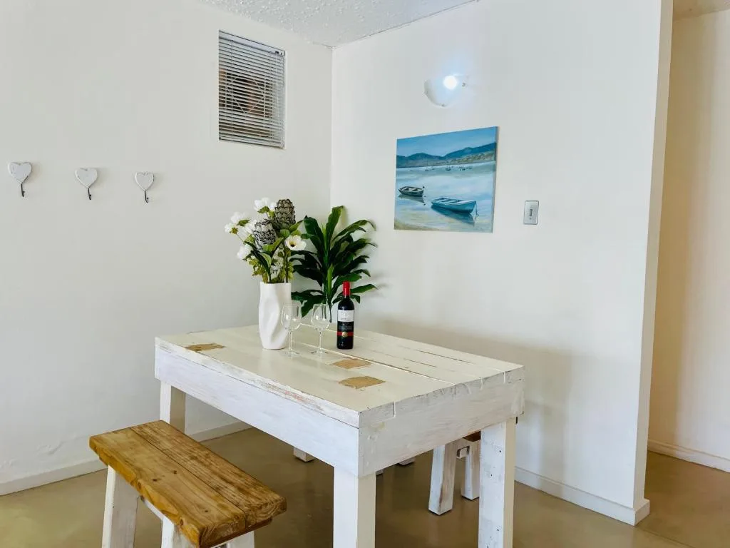 Dining table with fresh flowers, wine bottle, and coastal artwork decoration