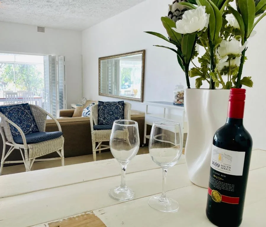 Wine bottle and glasses with fresh flowers on bright countertop