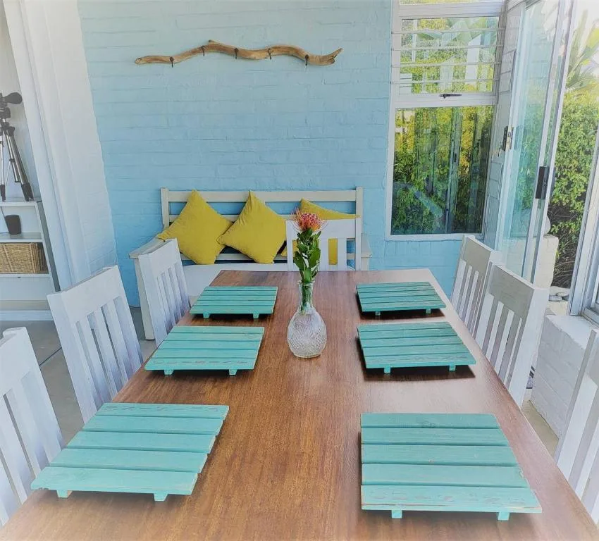 Bright blue dining room with wooden table and turquoise placemats