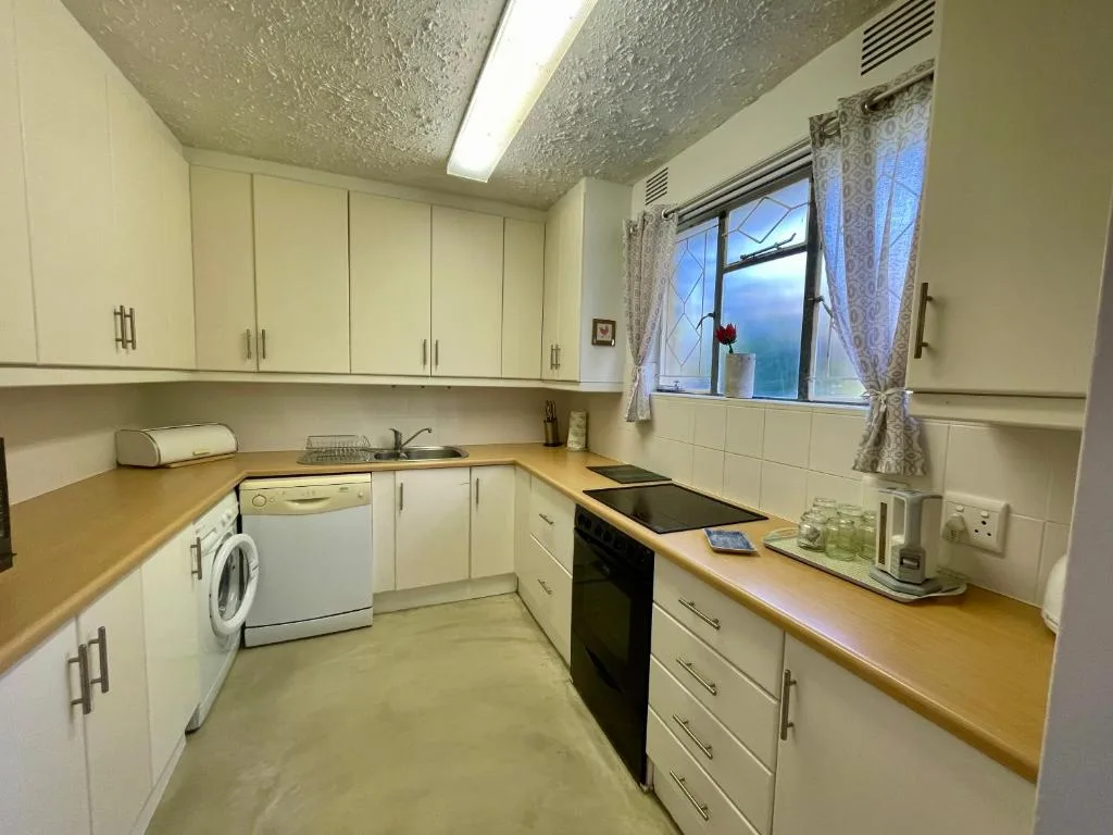 Well-equipped kitchen with cream cabinetry, wooden counters, and modern appliances