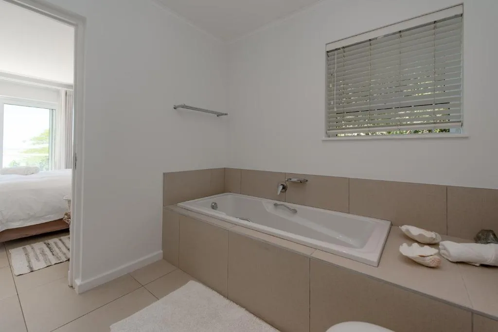 Spacious bathroom with built-in bathtub and neutral tile finishes