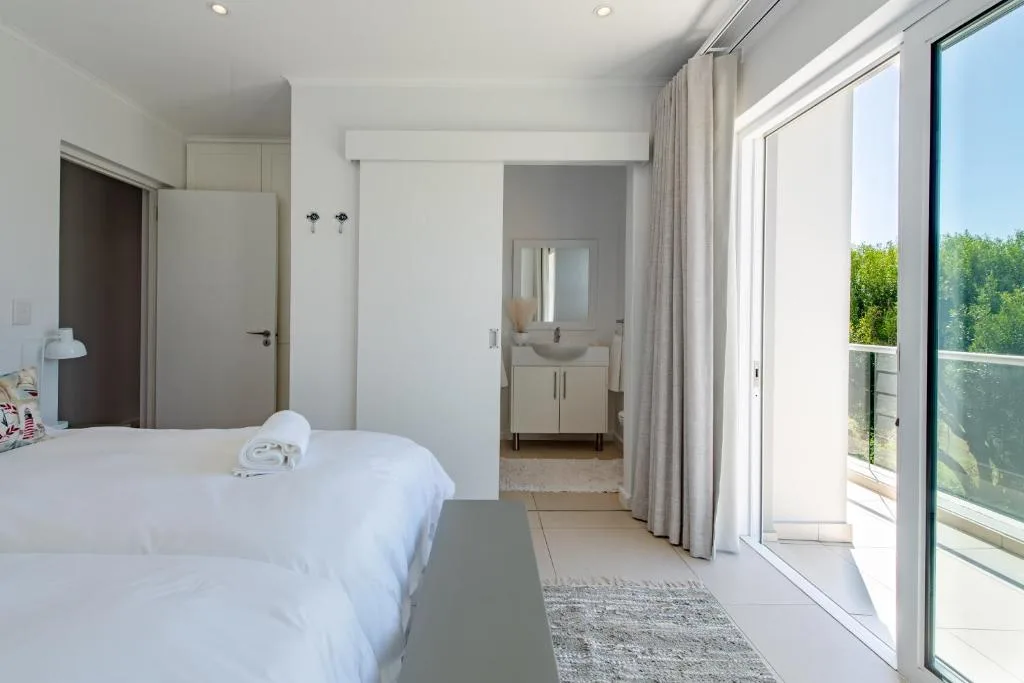 Bright modern bedroom with twin bed and ensuite bathroom access