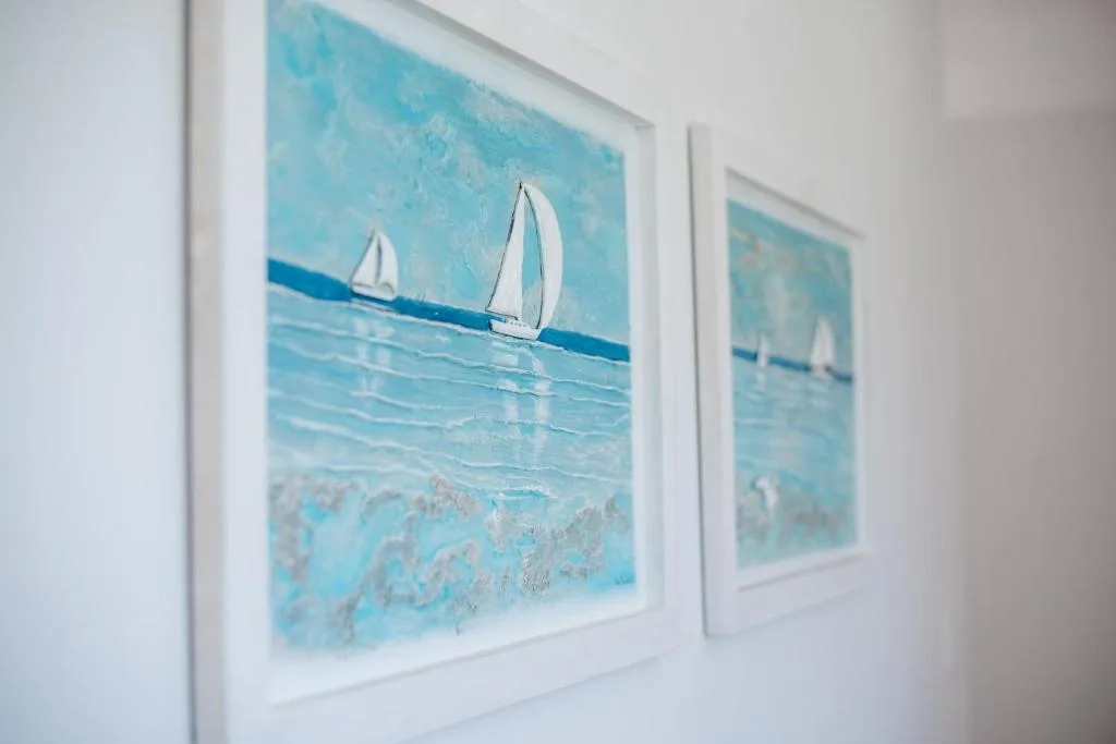 Framed sailboat artwork depicting ocean waves and white sails