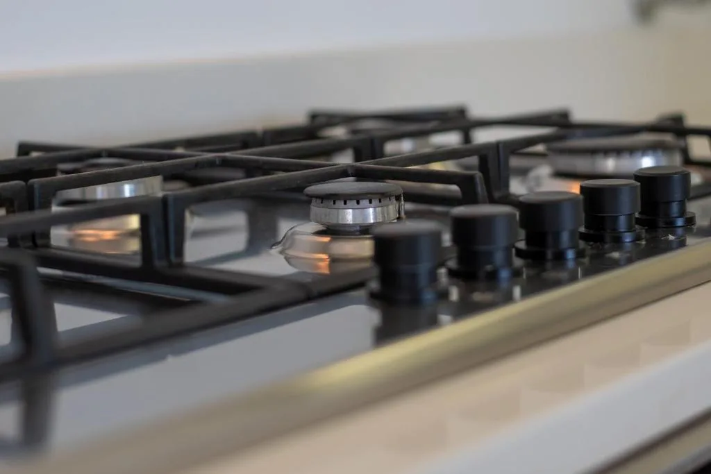 Close-up of gas stovetop burners and controls in modern kitchen