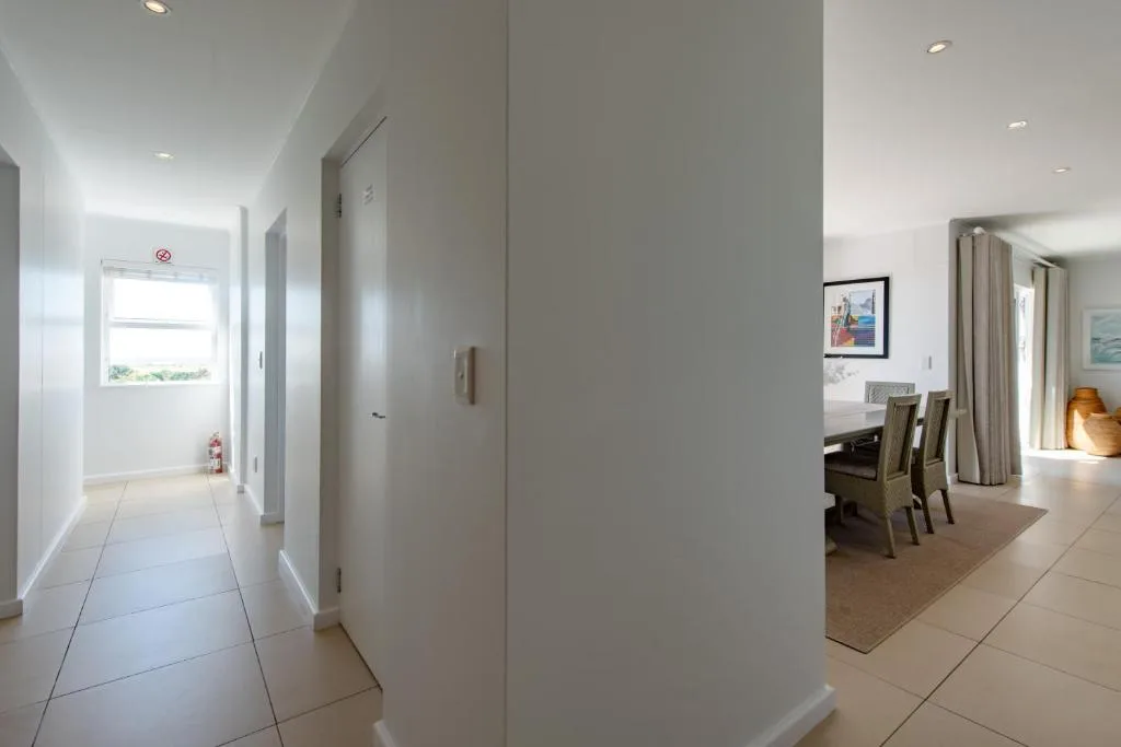 Bright hallway with tiled floors, white walls, and open-plan views