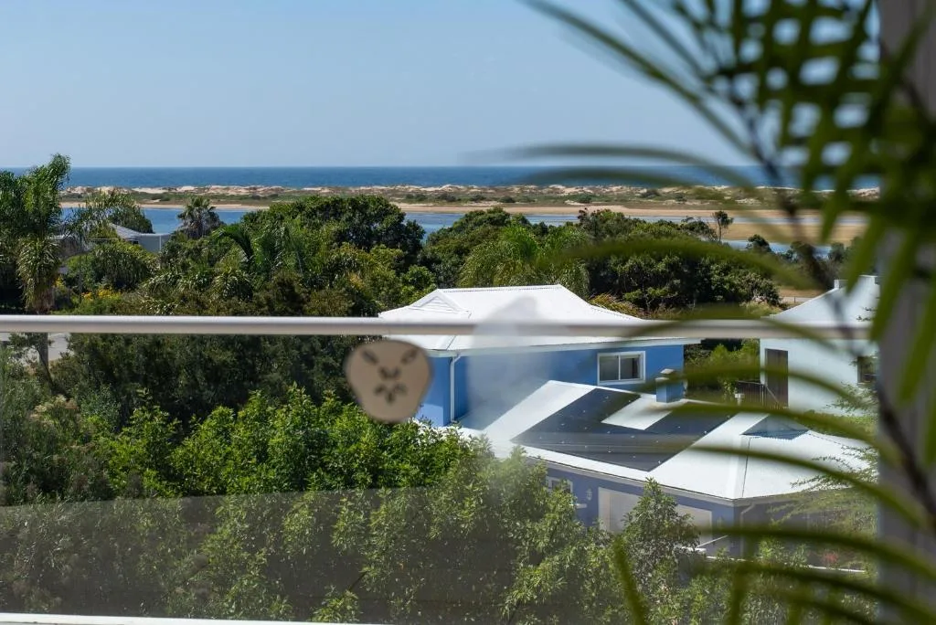 Scenic coastal view of lagoon and ocean beyond lush green vegetation