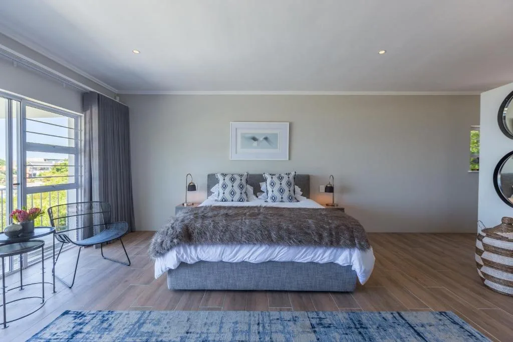 Spacious bedroom with king bed, modern decor, and garden views