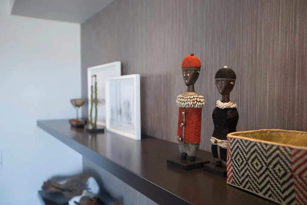 Decorative shelf with African art figurines and woven basket accents