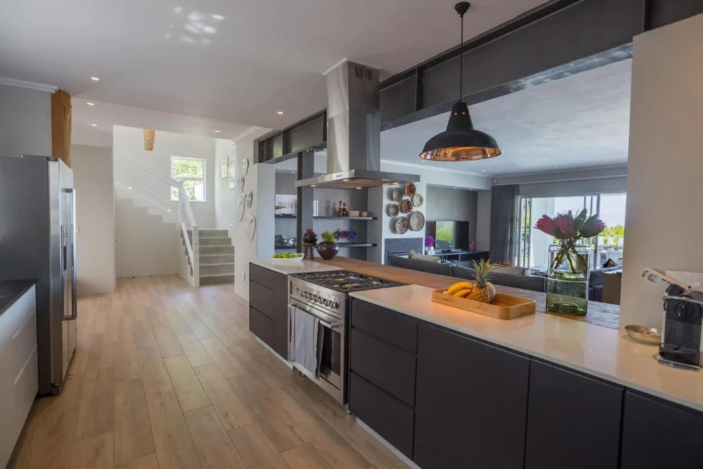 Modern kitchen with island, stainless steel appliances, and open-plan living area