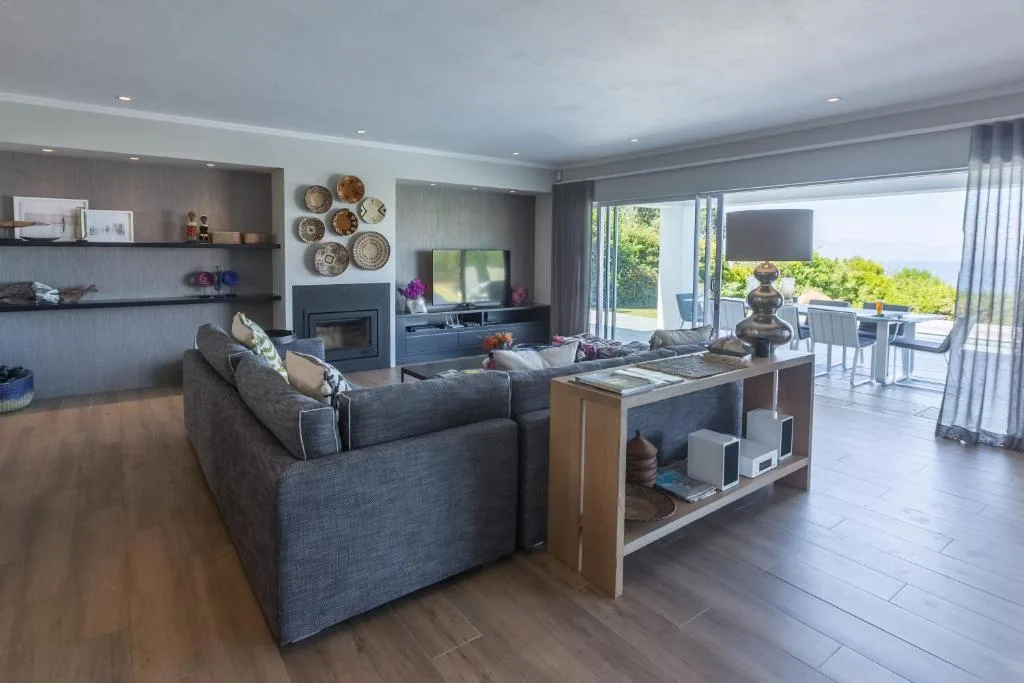 Modern living room with charcoal sofa, fireplace, and garden views