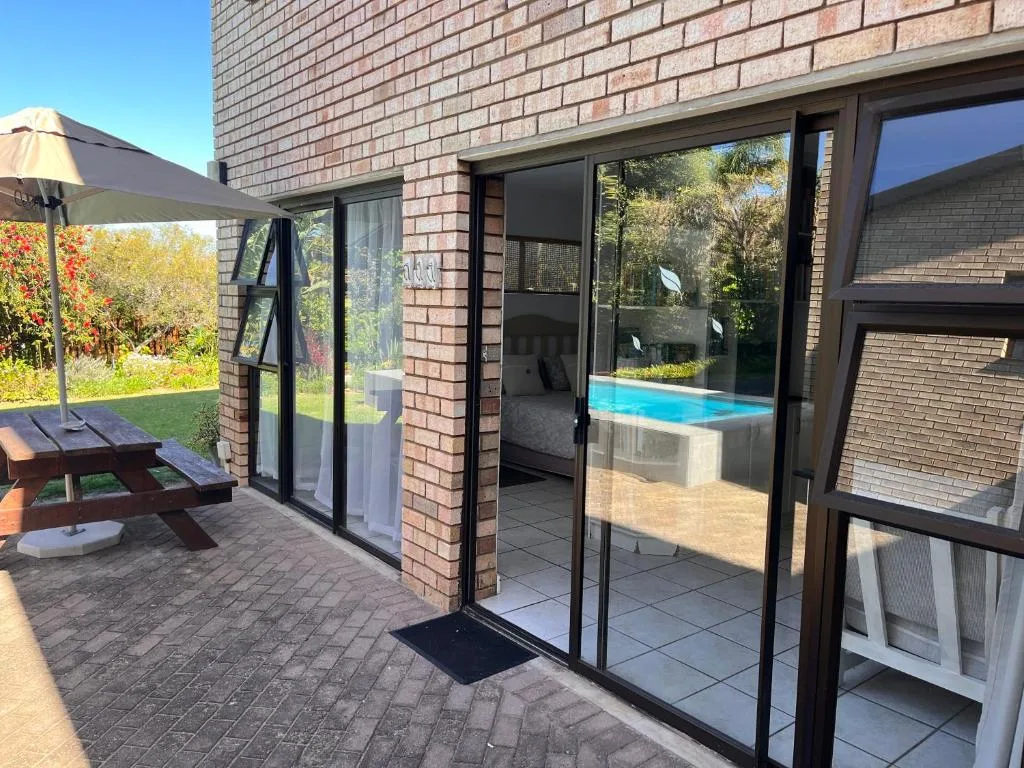 Patio area with picnic table, umbrella, and pool view access