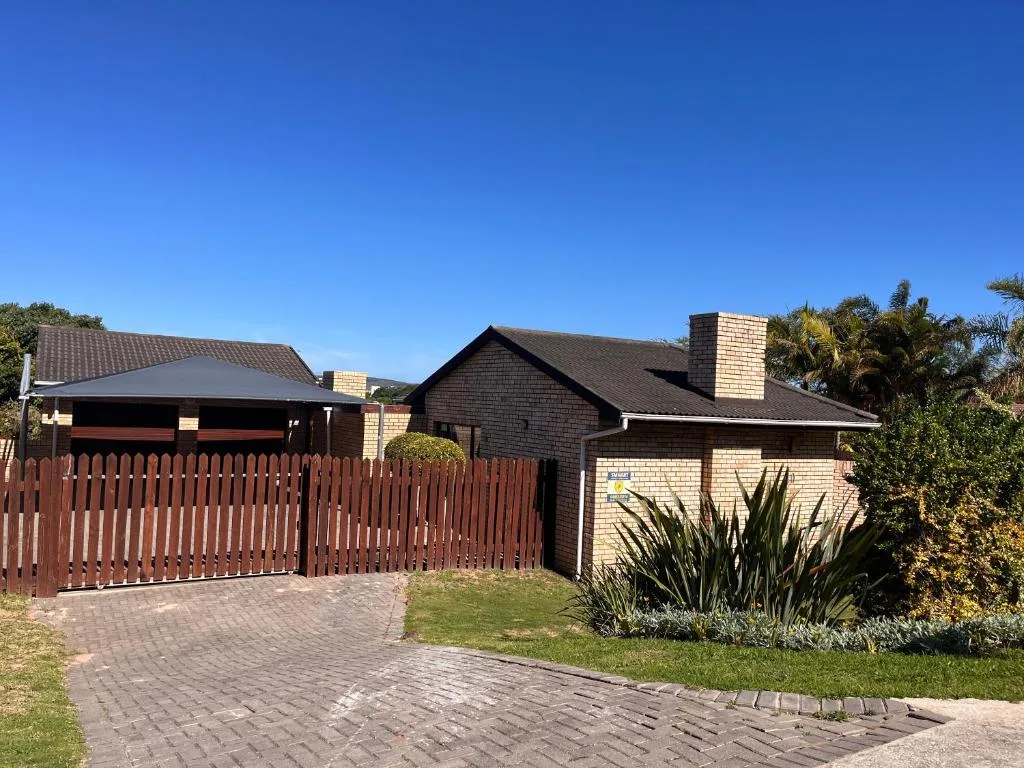 Modern brick and stone residential property with red-trimmed garage and manicured gardens
