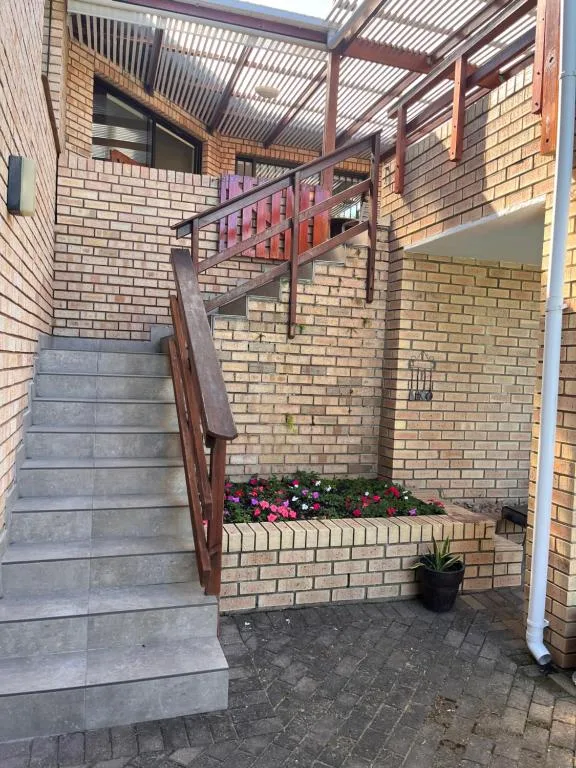 Brick exterior with metal staircase and flowering planter boxes