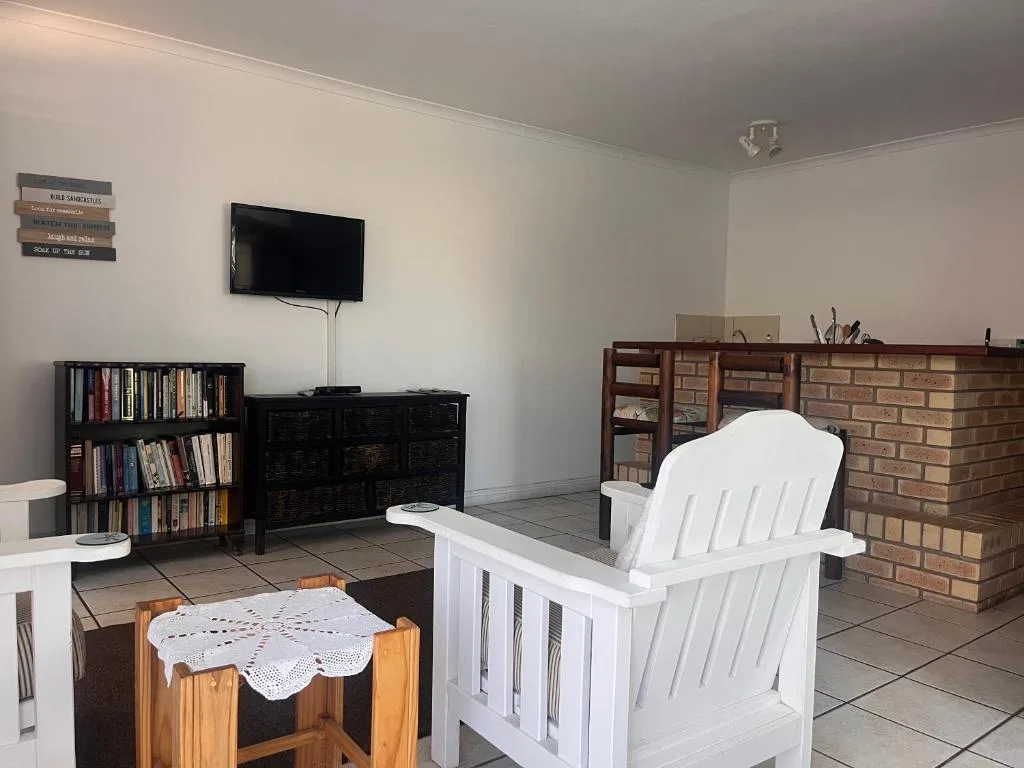 Spacious living room with white Adirondack chair and brick fireplace