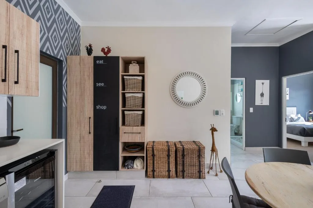 Modern kitchen and lounge with decorative wall mirror and woven storage baskets