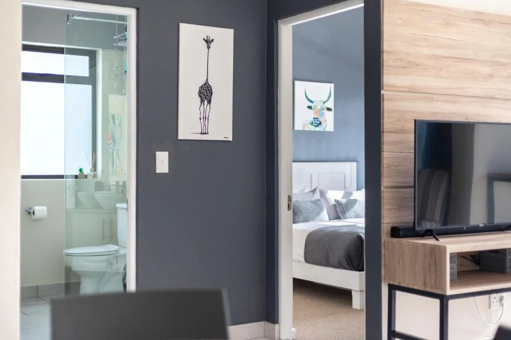 Modern apartment interior showing bathroom, bedroom, and lounge areas with contemporary decor