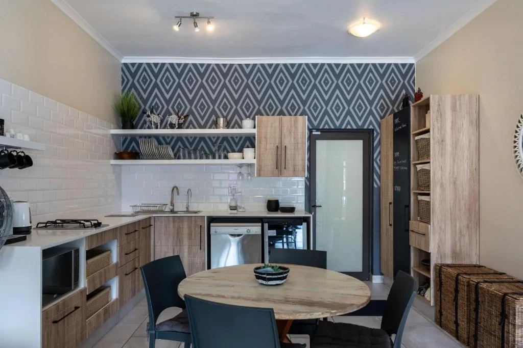 Modern kitchen with wooden cabinetry, white subway tiles, and dining table