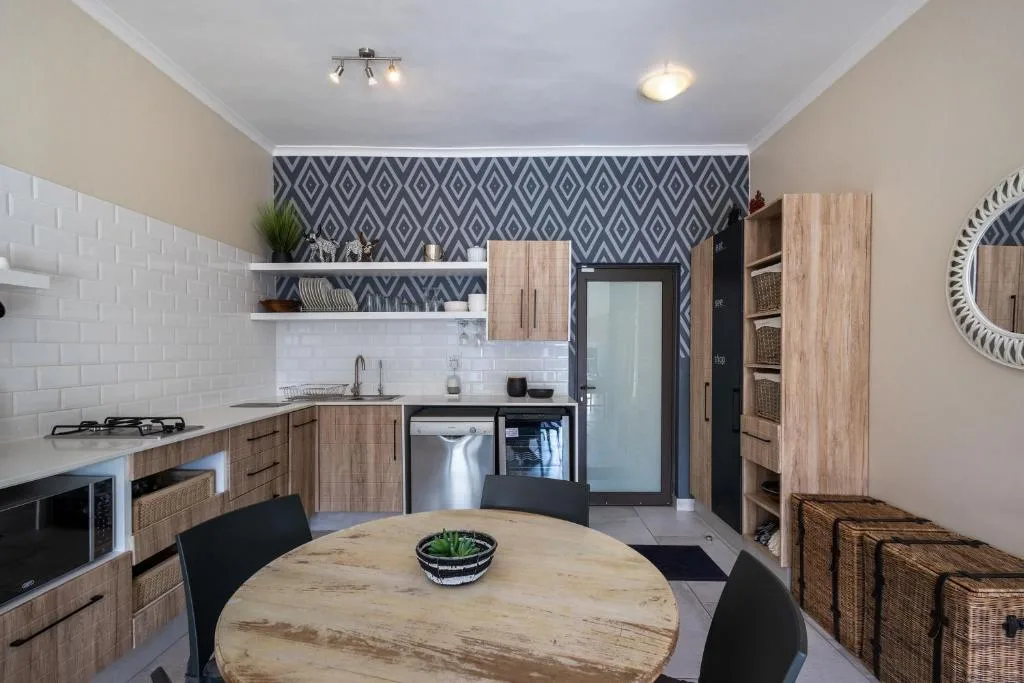Modern kitchen with wooden cabinetry, white subway tiles, and dining table