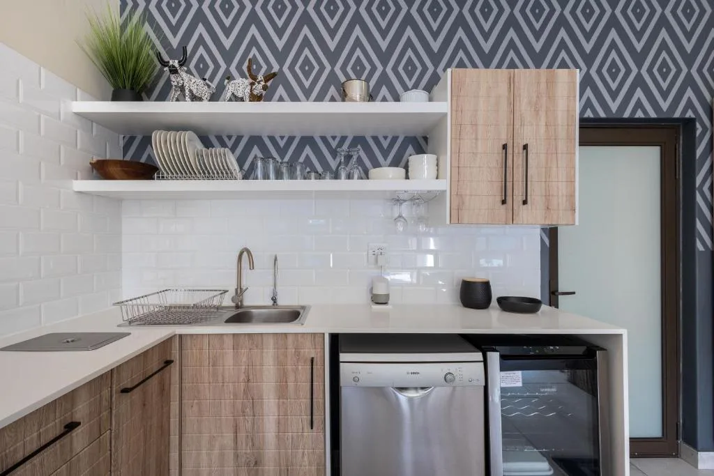 Modern kitchen with white counters, wooden cabinetry, and stainless steel appliances
