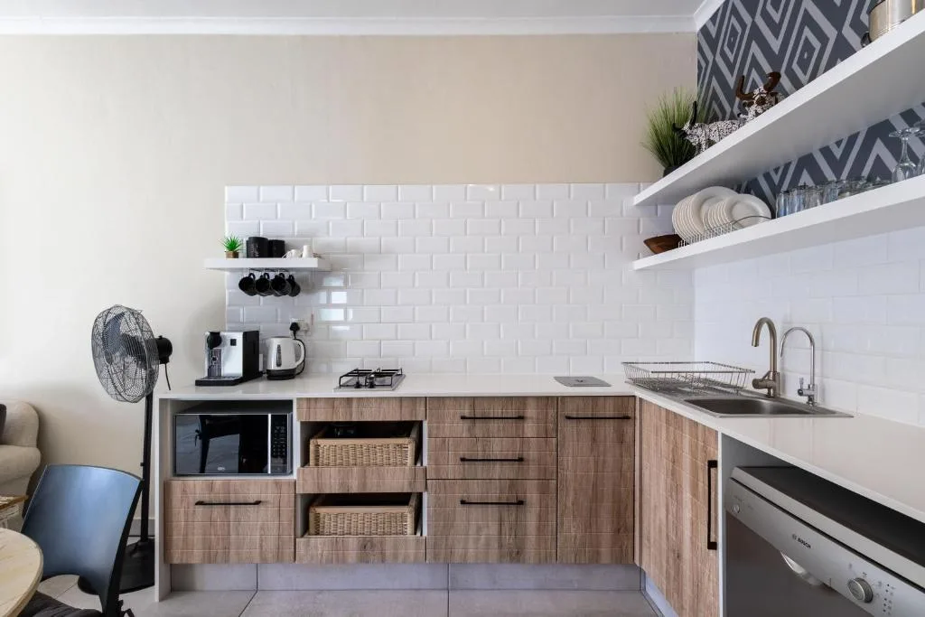 Modern kitchen with white subway tile backsplash, wooden cabinetry, and stainless steel appliances