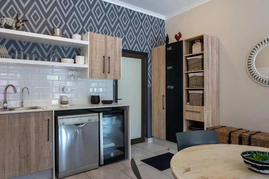 Modern kitchen with wooden cabinetry, dishwasher, and geometric patterned backsplash