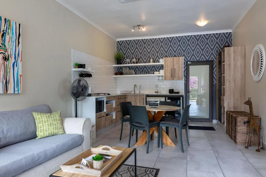 Open-plan lounge with gray sofa and kitchen area in background