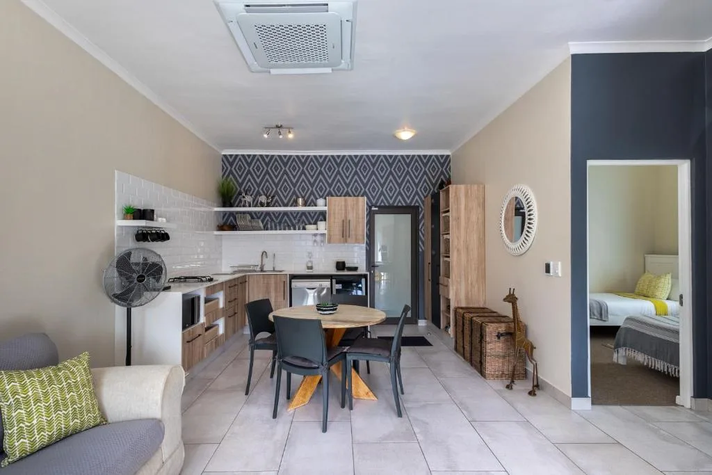 Open-plan lounge with sofa, dining table, and integrated kitchen area