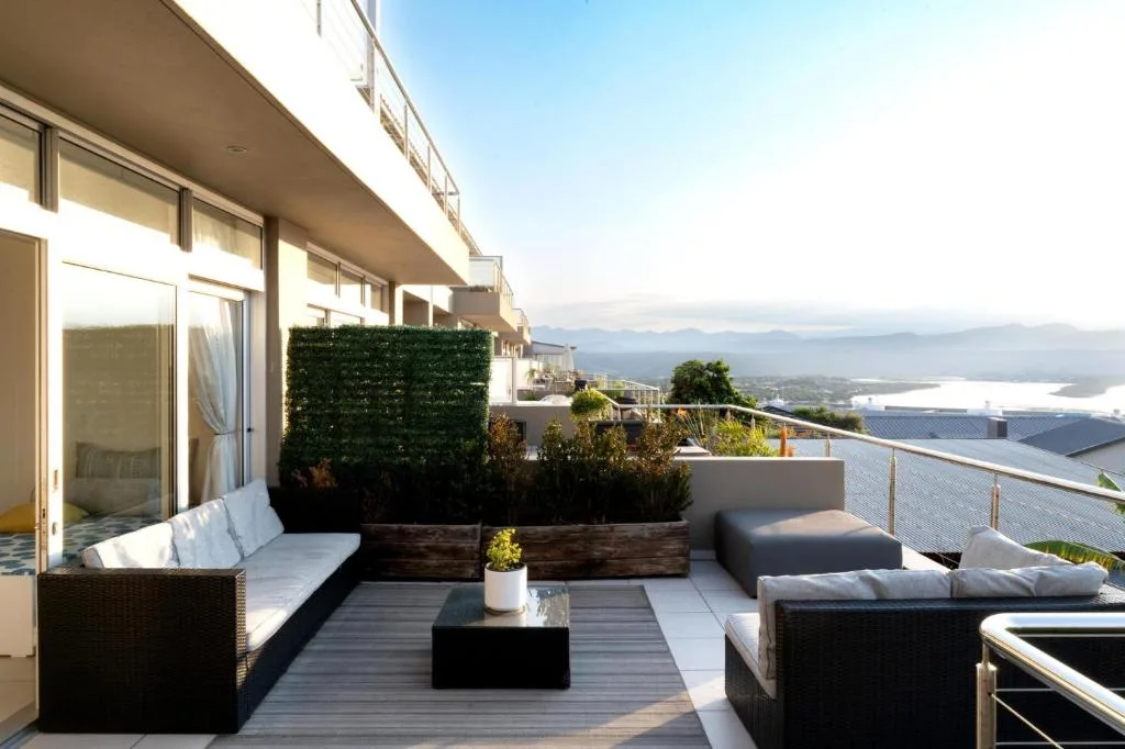 Spacious outdoor deck with seating, planters, and lagoon views