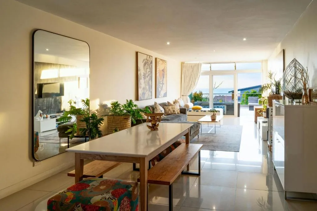 Modern dining table with bench seating overlooking coastal garden route landscape