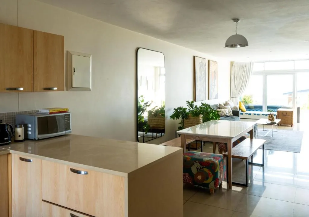 Modern kitchen with wooden cabinetry, island counter, and ocean view through windows