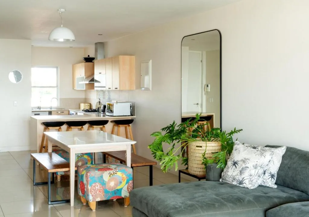 Modern lounge with gray sofa, dining area, and open kitchen visible