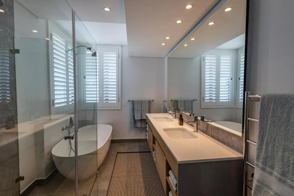 Modern bathroom with double vanity, freestanding tub, and walk-in shower