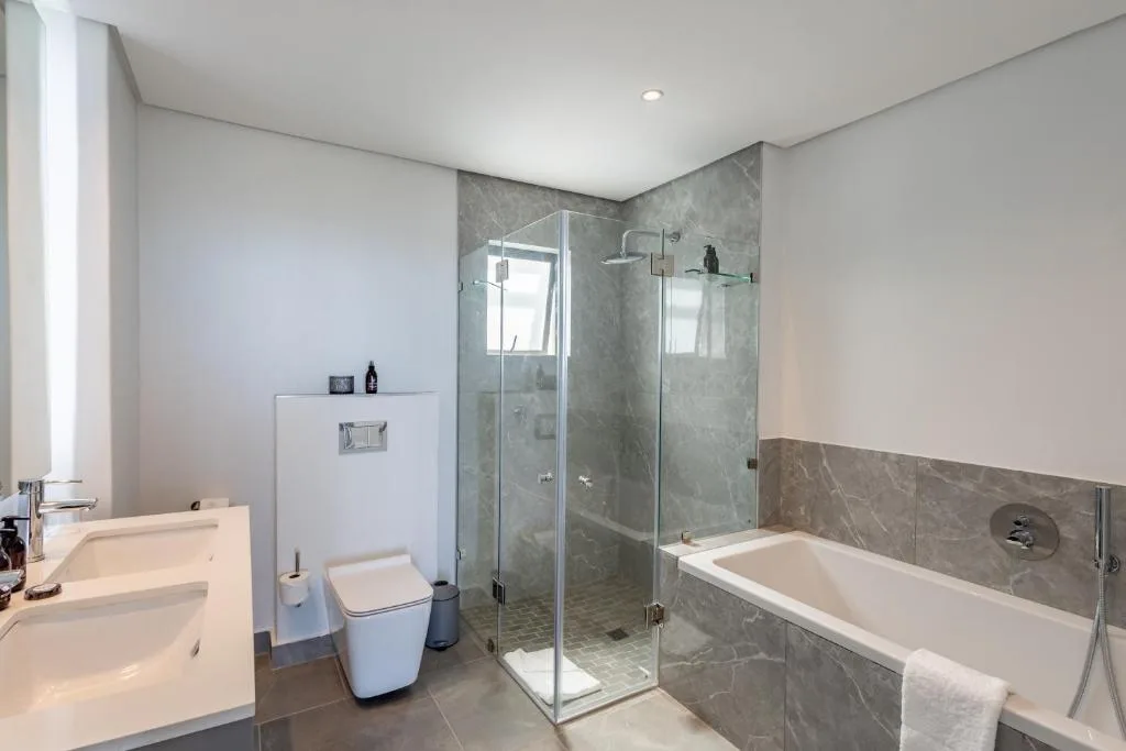 Modern bathroom with walk-in shower, soaking tub, and dual vanities