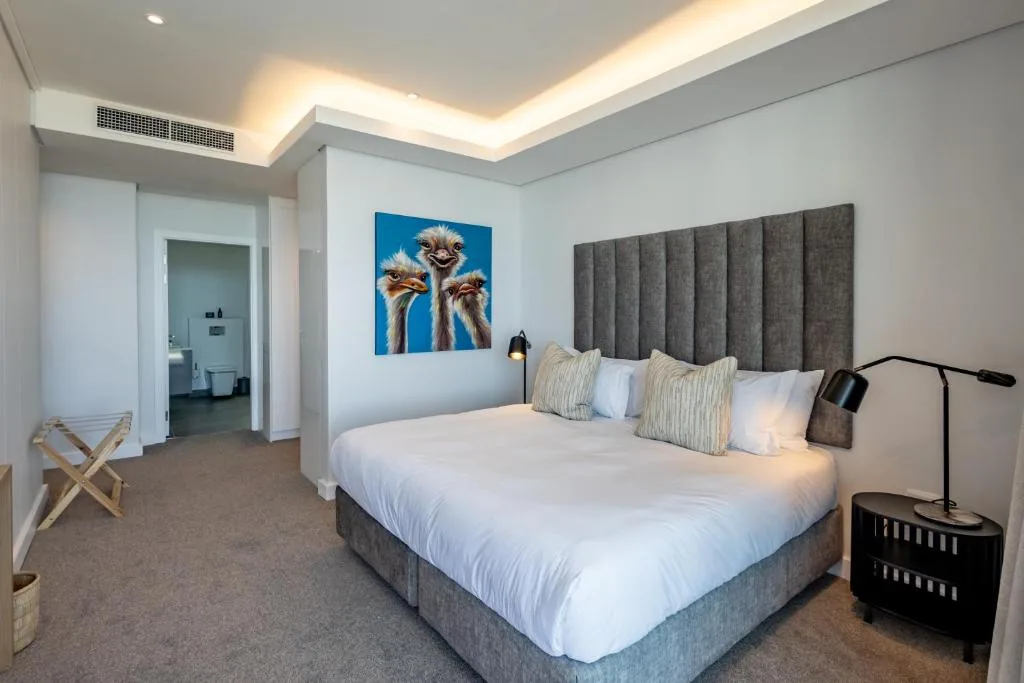 Modern bedroom with gray upholstered headboard and white bedding, contemporary decor