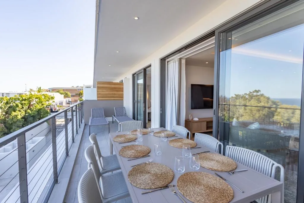 Spacious outdoor deck with dining table overlooking Plettenberg Bay views