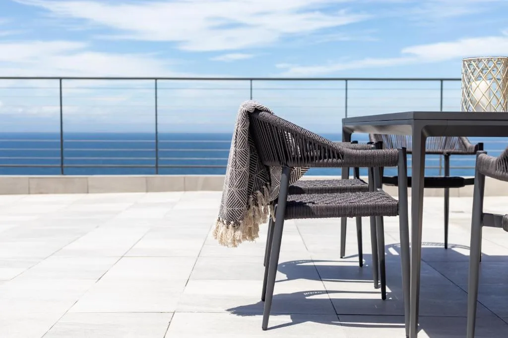 Oceanview deck with modern dining furniture and coastal sea views