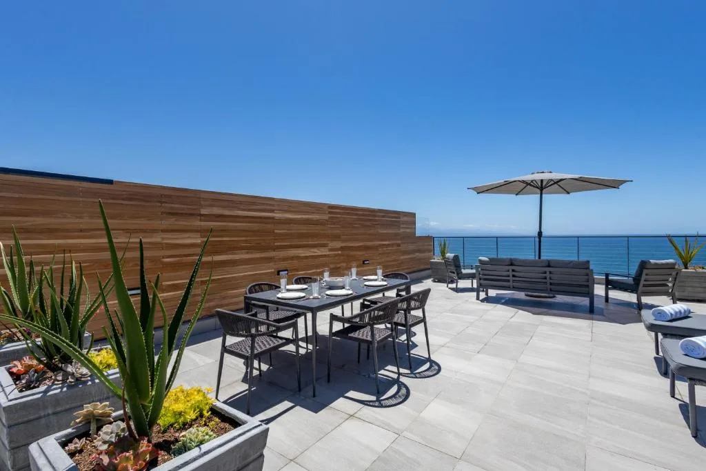 Oceanfront deck with dining table, lounge seating, and sea views